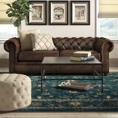 a living room filled with furniture and framed pictures on the wall above it's windows