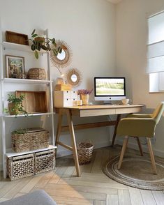 a desk with a computer on top of it in front of some baskets and plants