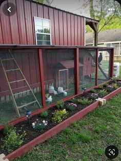 a red chicken coop with chickens in it and plants growing out of the bottom half