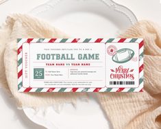 a football ticket sitting on top of a white plate next to a red and green striped napkin