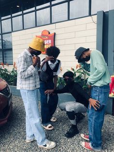 three men standing next to each other in front of a building with plants growing out of it