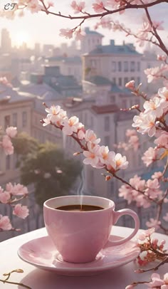 a cup of coffee sitting on top of a saucer next to a tree filled with pink flowers