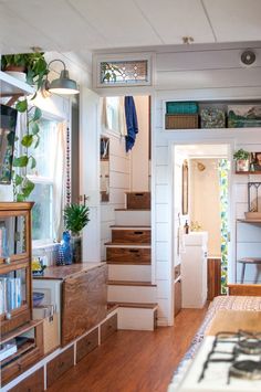 there is a room that has stairs in the house and some plants on the table