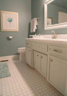 a bathroom with blue walls and white cabinets