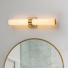 a bathroom light that is on the side of a wall above a sink and mirror