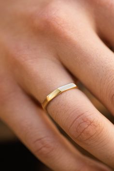 a woman's hand with a gold wedding ring on top of her left hand