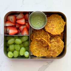 a metal container filled with fruit and veggies next to two pancakes on top of each other