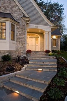 a house with steps leading up to the front door and lights on either side of it