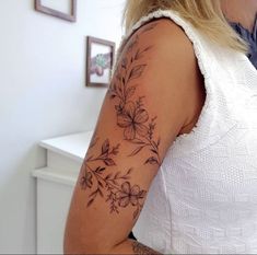 a woman's arm with flowers on it, and the back of her shoulder