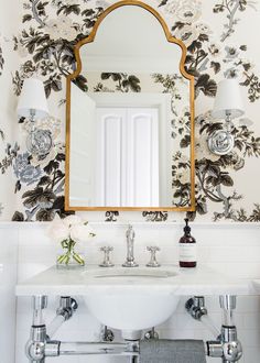 the bathroom is decorated with black and white wallpaper, gold trimmings, and an ornate mirror