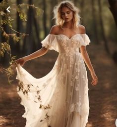 a woman in a white dress is walking through the woods with her hand on her hip