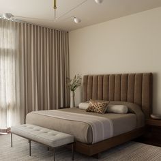 a bedroom with a large bed and beige curtains