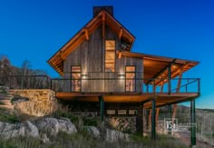 a large wooden house sitting on top of a hill