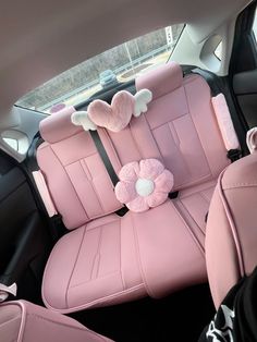 the interior of a car with pink leather seats and flower decorations on it's headrests