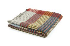 three blankets folded on top of each other in different colors and patterns, with one blanket folded