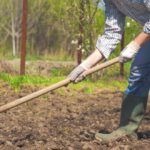 a man is digging in the dirt with a shovel