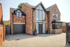 a large brick house with lots of windows and garage doors on the front of it