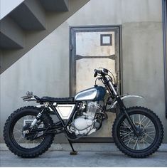 a motorcycle is parked in front of a door and steps that lead up to it