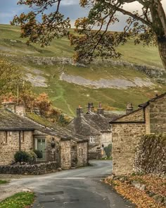 an old village with stone buildings and trees in the foreground