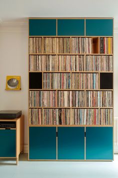 a bookcase filled with lots of books next to a desk and chair in a room