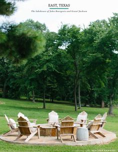 a wooden table and chairs sitting on top of a grass covered field next to trees