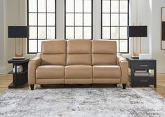 a tan leather couch sitting on top of a rug