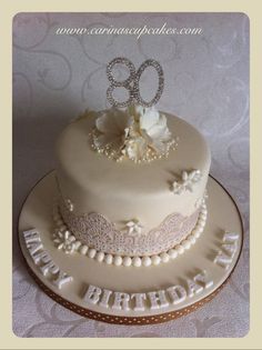 a white cake with the number 80 on it's side and flowers in the middle