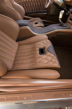 the interior of a luxury car with tan leather and black stitching on the floor