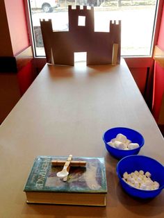 two bowls of marshmallows sit on a table in front of a window