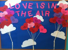 a bulletin board with hearts and the words love is in the air