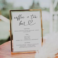 a sign that says coffee and tea on it sitting on top of a wooden table