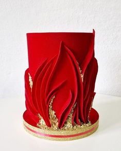 a red hat with gold sequins on the top and bottom, sitting on a white surface