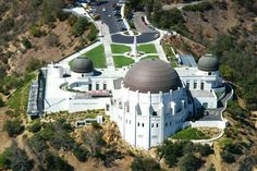 an aerial view of a large white building in the middle of a mountain side area