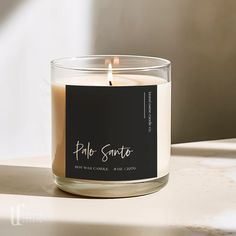 a candle is sitting on a table with a label that says pebble santao