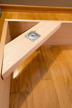 a close up of a wooden shelf with a metal object in it's center