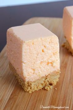 two pieces of cake sitting on top of a wooden cutting board next to each other