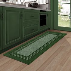 a kitchen with green cabinets and wooden floors is pictured in this image, there is a rug on the floor