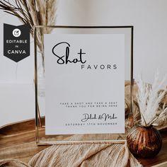 a sign that says shot favors next to a vase with dried pamodia in it