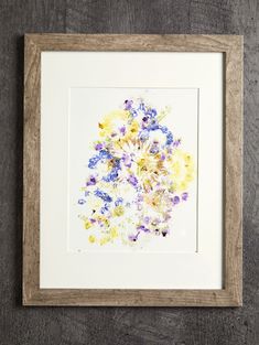 an art work with flowers in a wooden frame