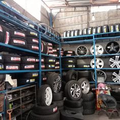 a garage filled with lots of tires and rims on shelves next to each other