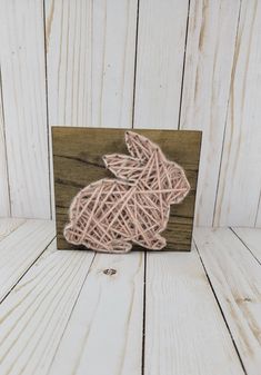 a string art bunny on a wood block