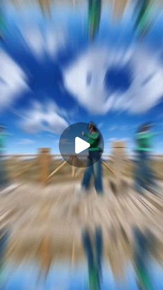 blurry image of people walking in the desert with blue sky and clouds behind them