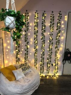 a living room with lights and plants on the wall behind a bean bag chair in front of a hanging planter