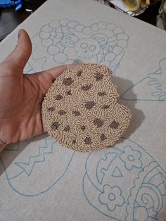 a hand is holding a piece of crocheted fabric