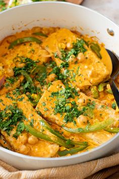 a pan filled with chicken and vegetables on top of a table