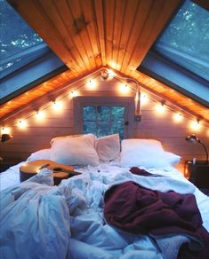 a bed with white sheets and pillows in a loft