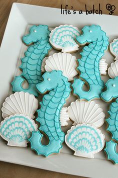 decorated cookies in the shape of seahorses on a plate