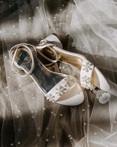 a pair of white shoes sitting on top of a veil