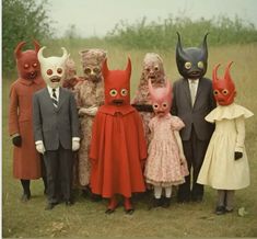 a group of people in costume standing next to each other with masks on their heads