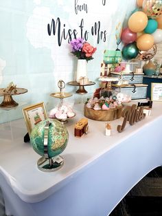 a table topped with lots of different types of items and balloons on top of it